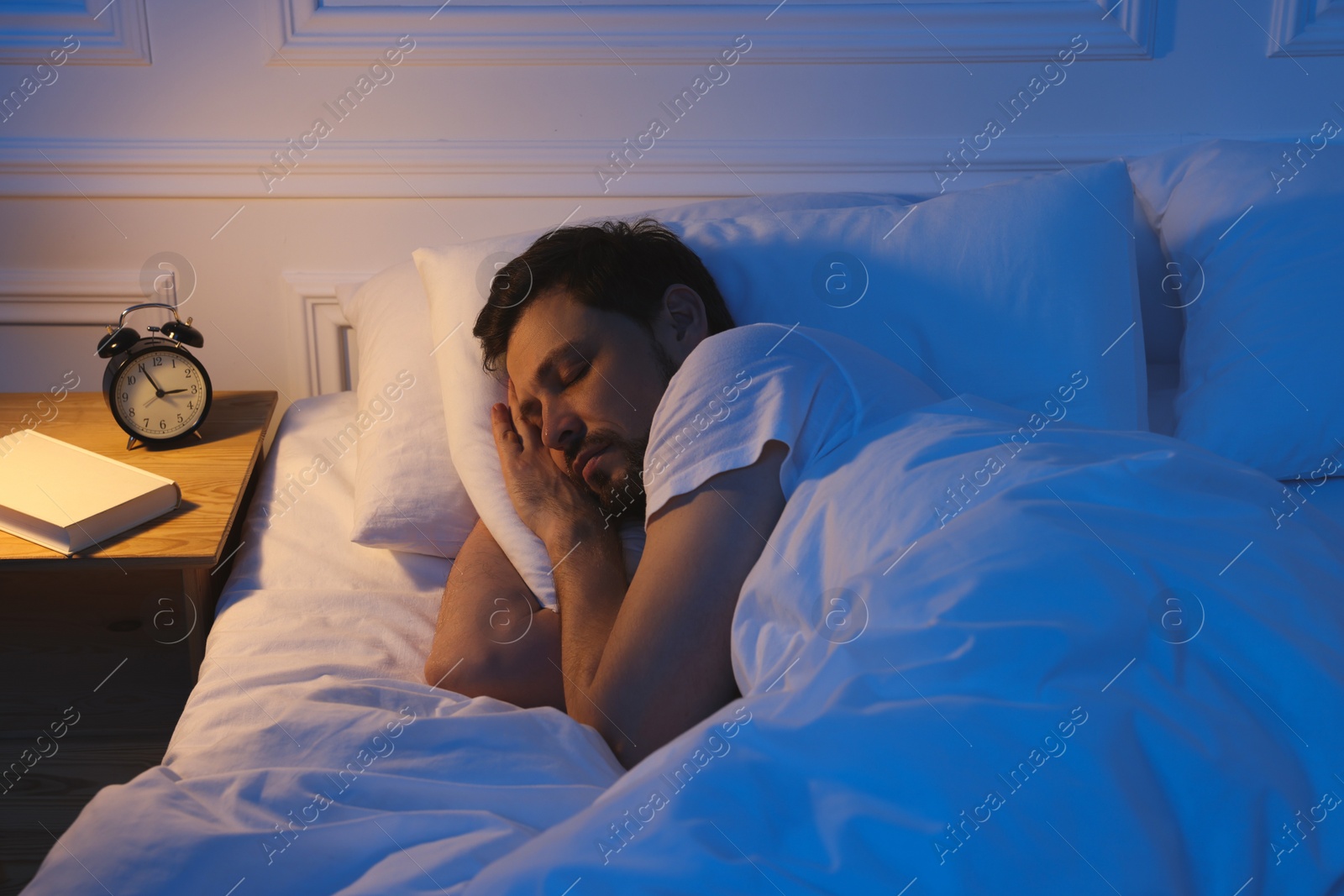 Photo of Handsome man sleeping in bed at night