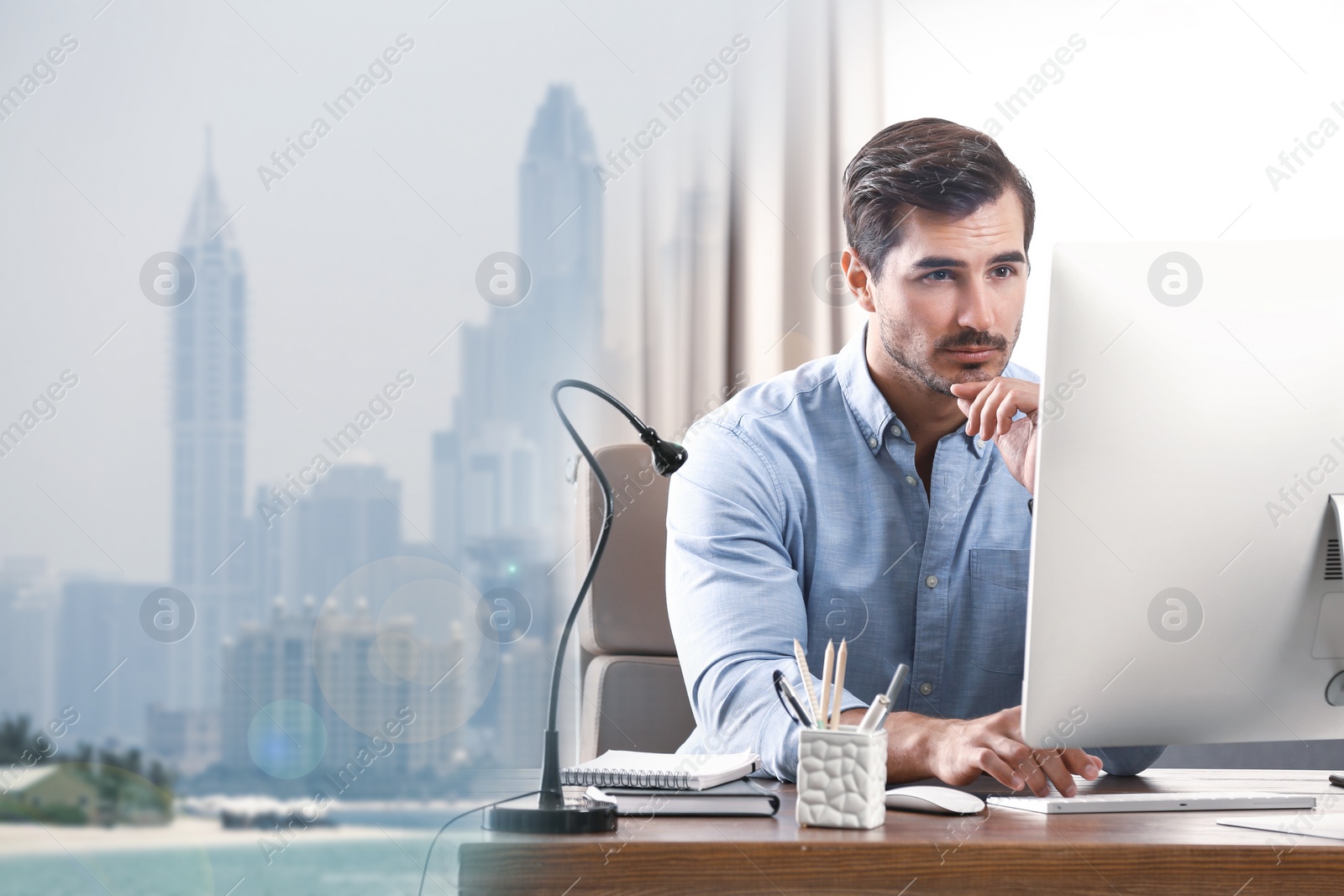 Image of Double exposure of architect working with computer at table and cityscape