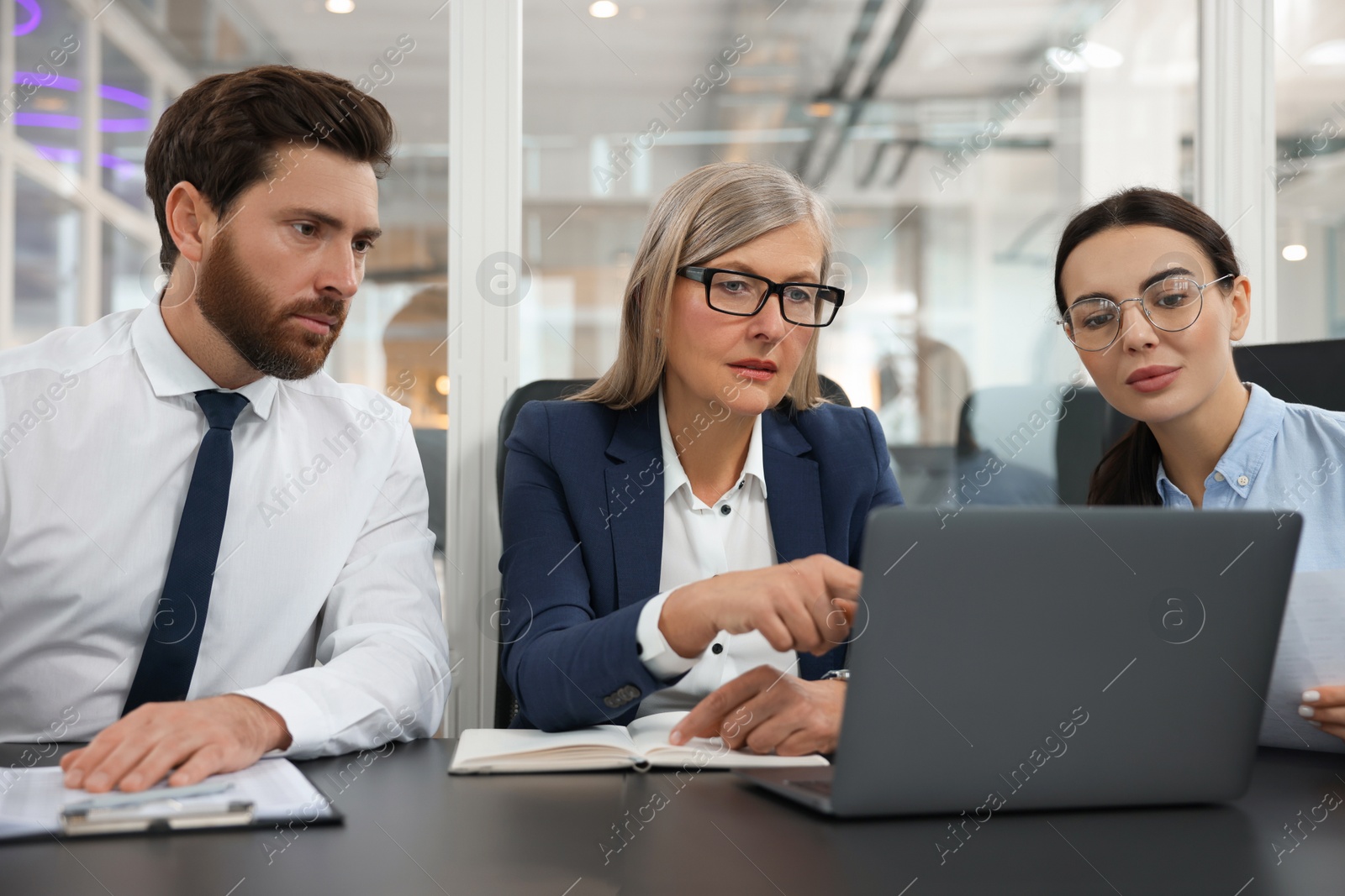 Photo of Lawyers working together with laptop at table in office