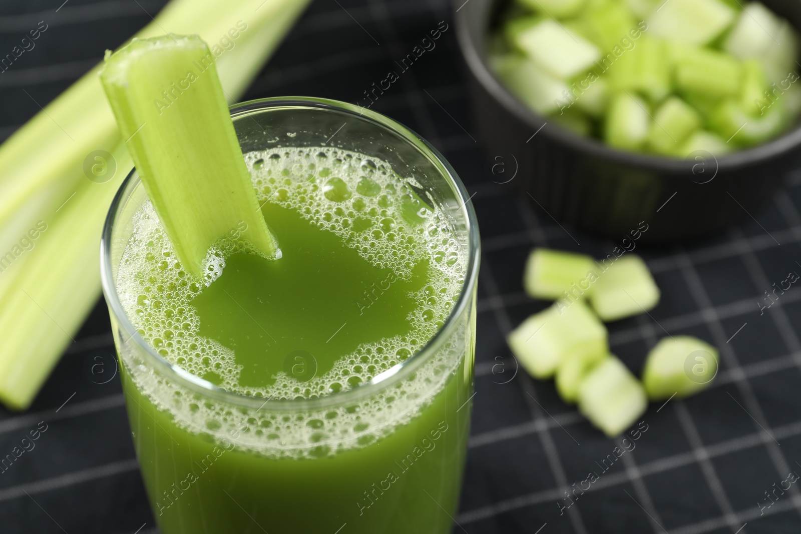 Photo of Glass of delicious celery juice and vegetables on cloth, closeup