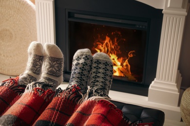 Photo of Couple resting near fireplace at home, closeup