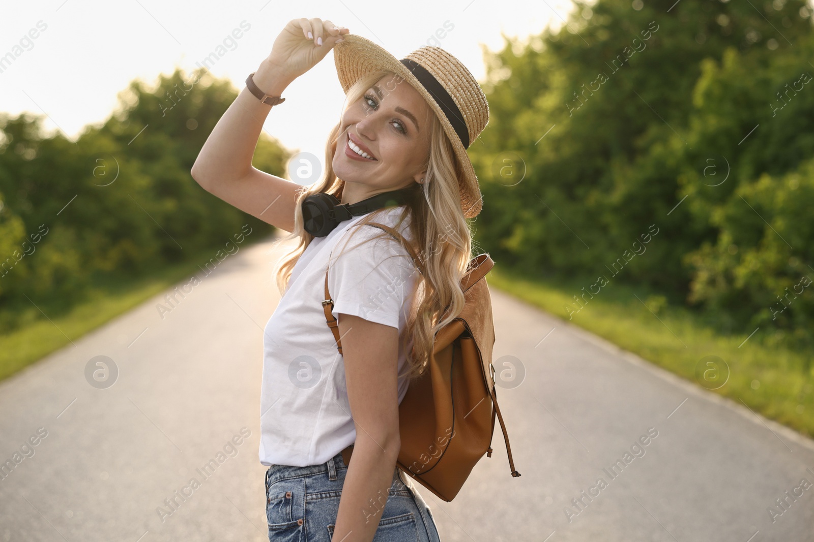 Photo of Happy young woman with headphones in park on spring day