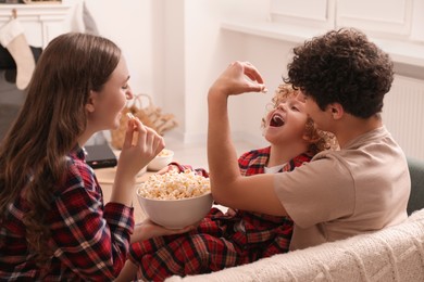 Family spending time together at home. Eating popcorn