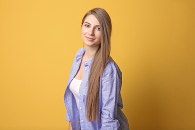 Portrait of young woman with long beautiful hair on color background