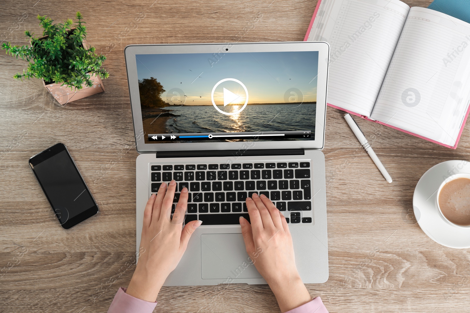 Image of Woman watching video on laptop at office desk, closeup. Top view