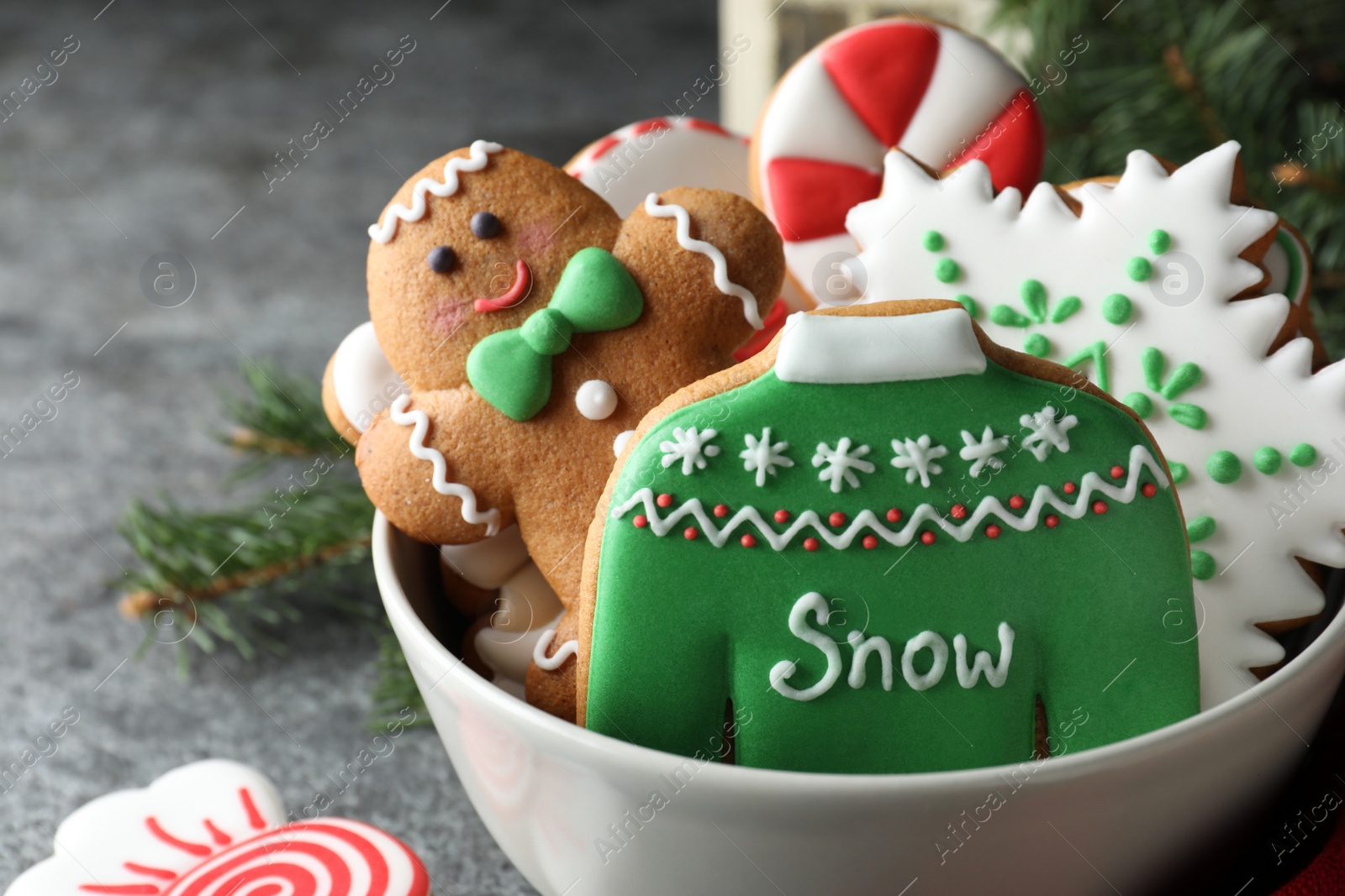 Photo of Delicious Christmas cookies in bowl on grey table, closeup