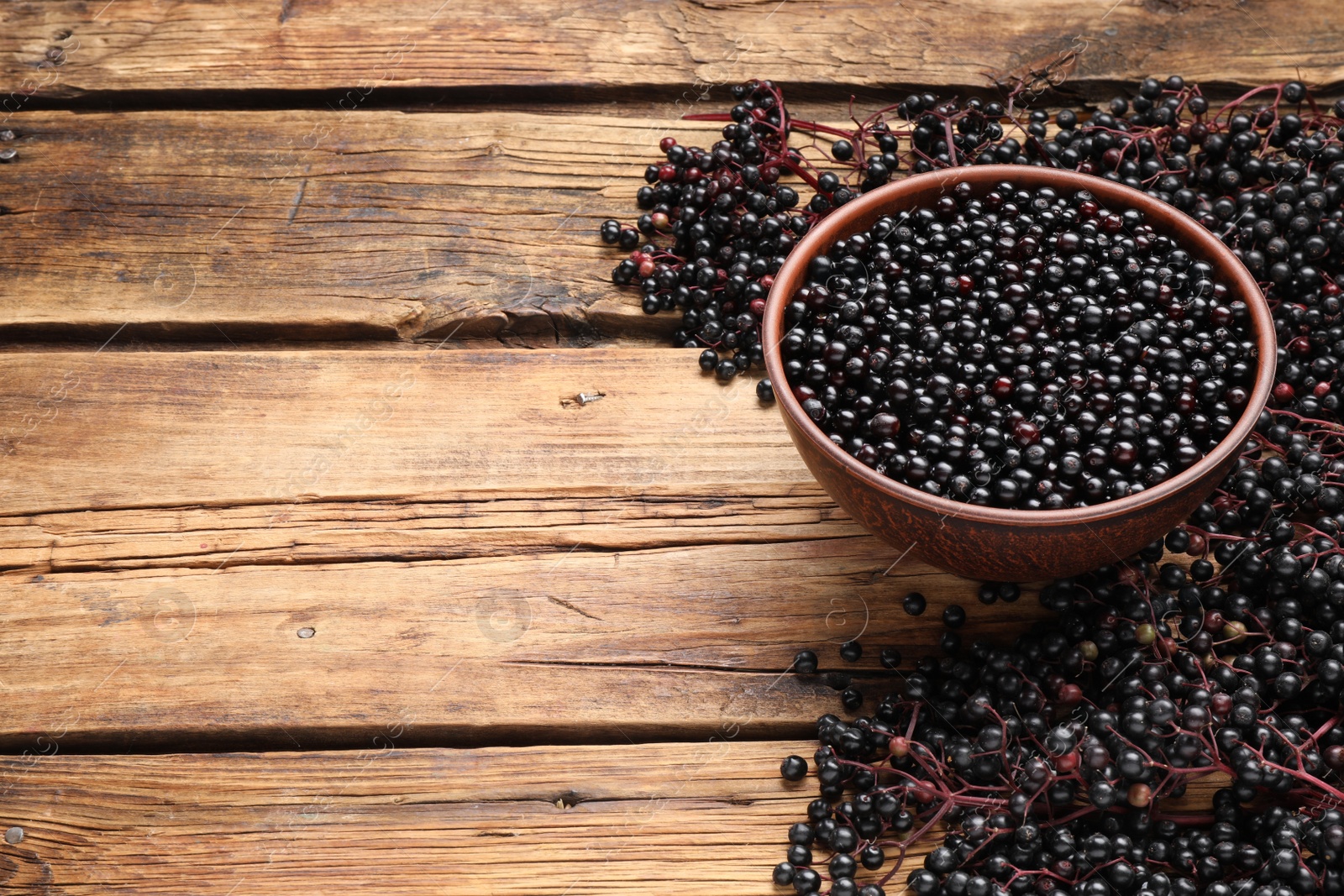 Photo of Elderberries (Sambucus) on wooden table. Space for text