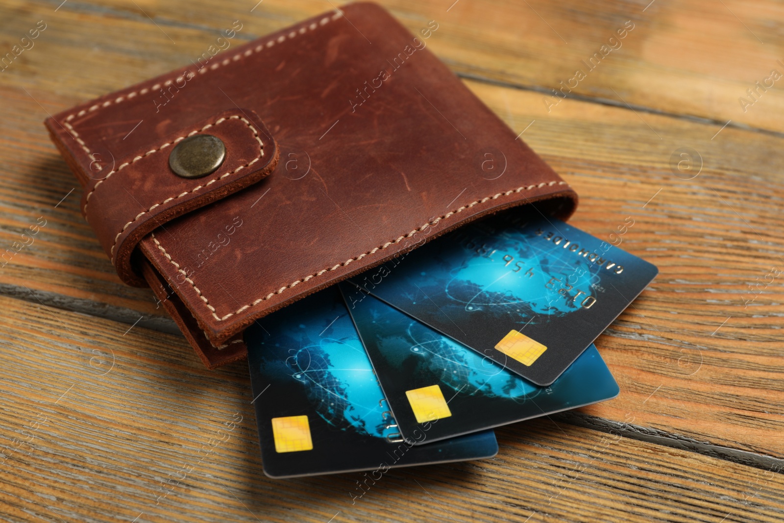 Photo of Credit cards in wallet on wooden table, closeup