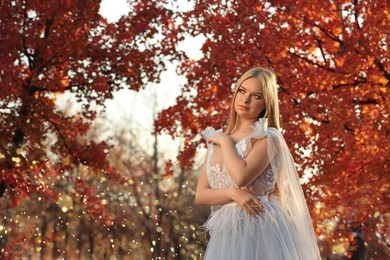 Photo of Beautiful girl wearing fairy dress in autumn forest