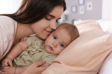 Photo of Happy young mother with her cute baby at home, closeup