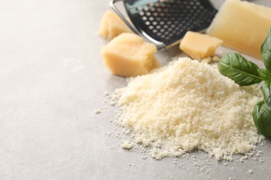 Photo of Pile of grated parmesan cheese on light table, closeup. Space for text