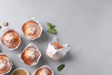 Photo of Delicious muffins on grey table, flat lay. Space for text