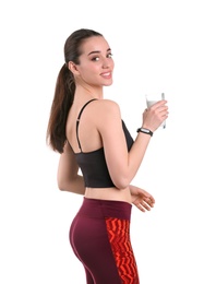 Beautiful young woman in sportswear drinking milk on white background