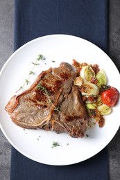 Photo of Delicious fried beef meat and vegetables on grey table, top view