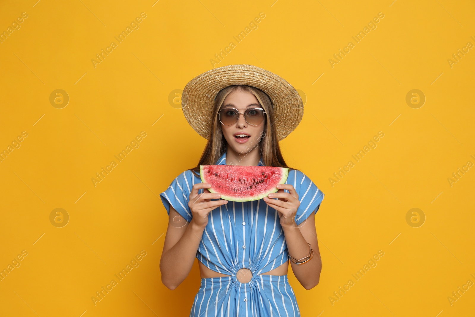 Photo of Beautiful girl with slice of watermelon on yellow background