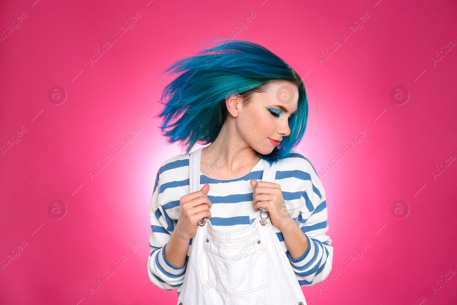 Photo of Young woman with bright dyed hair on pink background