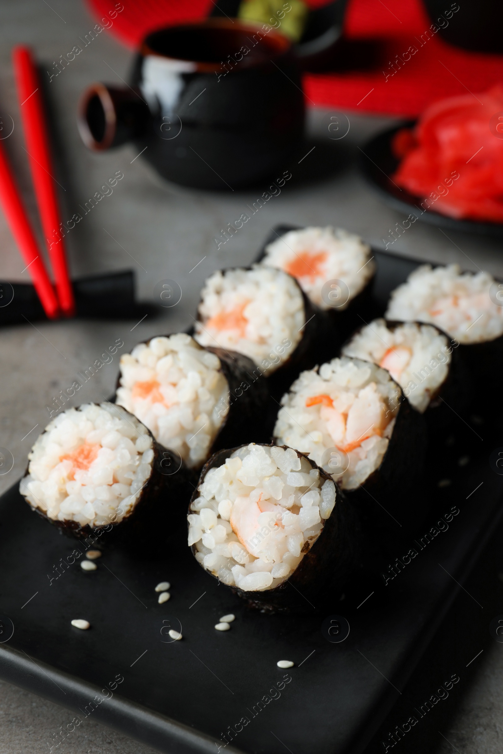 Photo of Tasty sushi rolls served on grey table, closeup