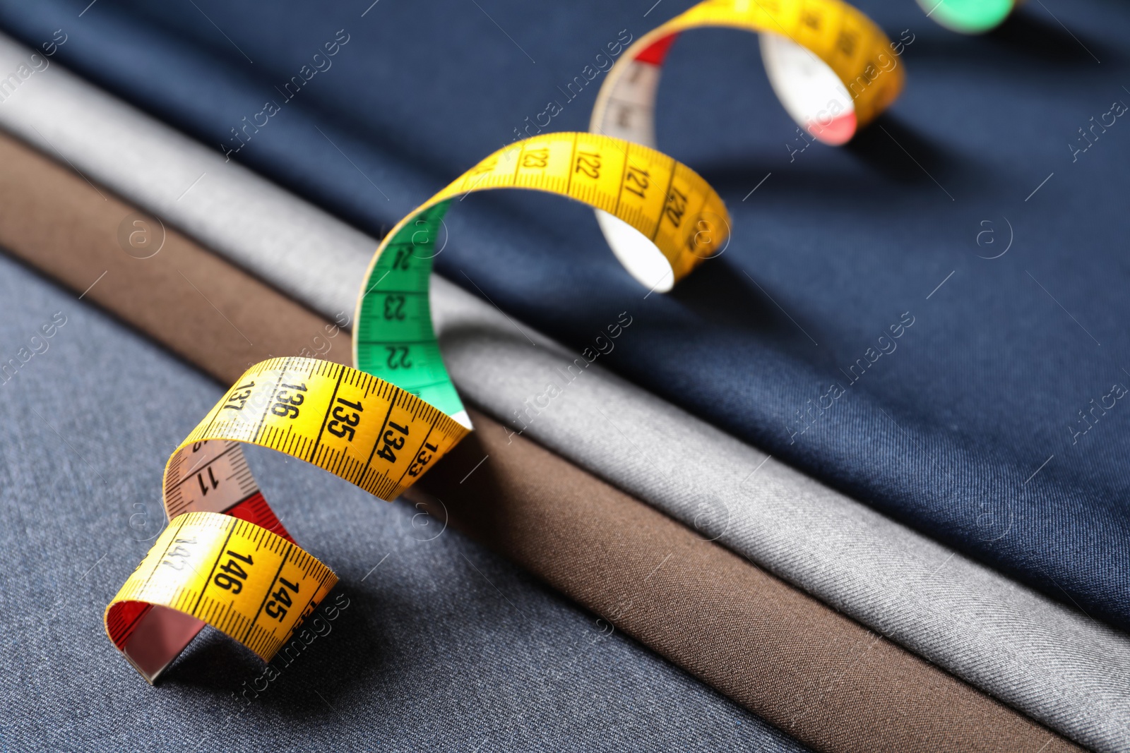 Photo of Measuring tape on fabric, closeup. Tailoring equipment