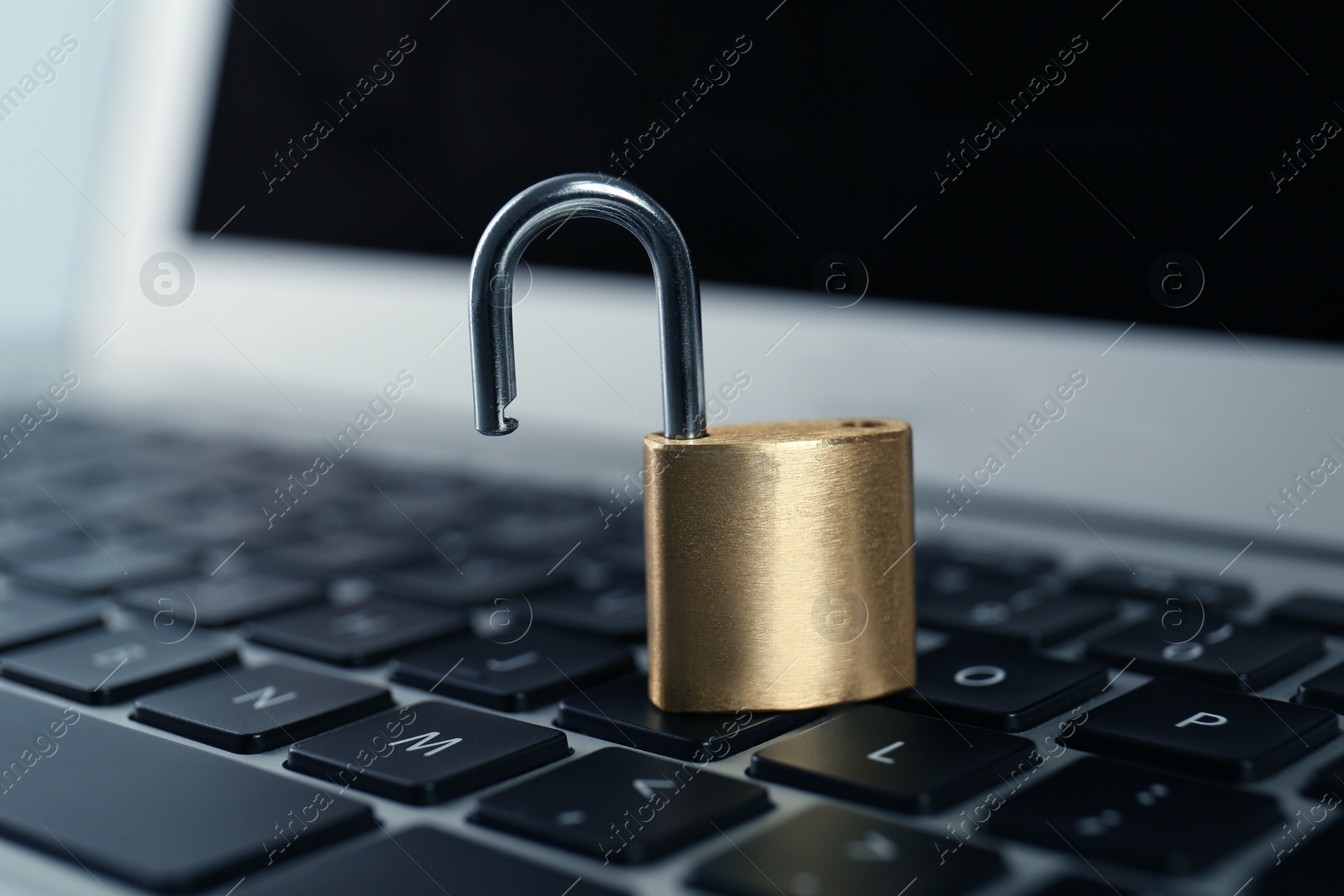 Photo of Metal padlock on laptop keyboard, closeup. Cyber security concept