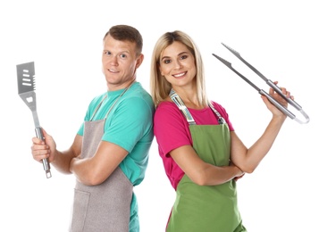 Photo of Happy couple with barbecue utensils on white background