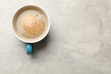 Photo of Cup of aromatic coffee on light grey table, top view. Space for text