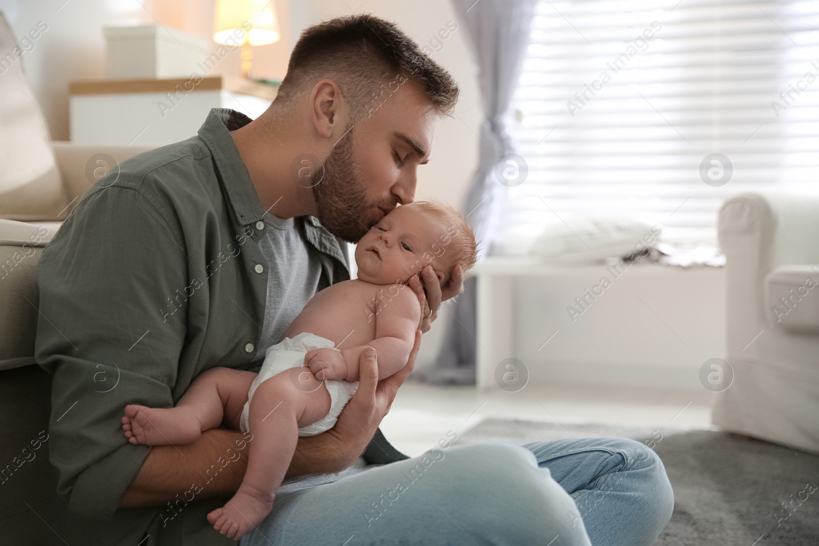 Photo of Father with his newborn son at home