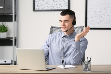 Hotline operator with headset working in office