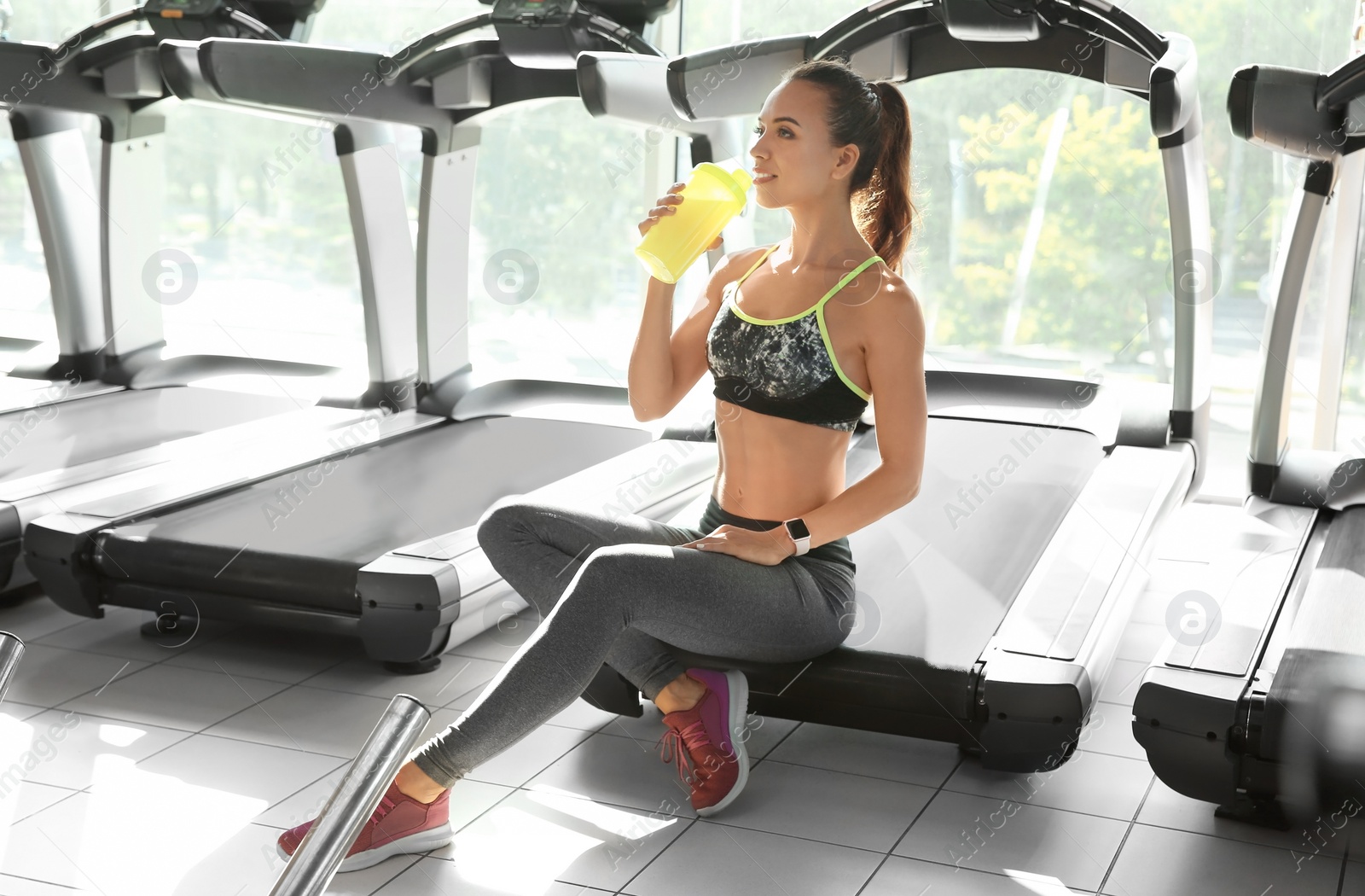 Photo of Portrait of athletic woman with protein shake in gym