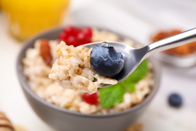 Spoon of oatmeal and blueberry at table, closeup