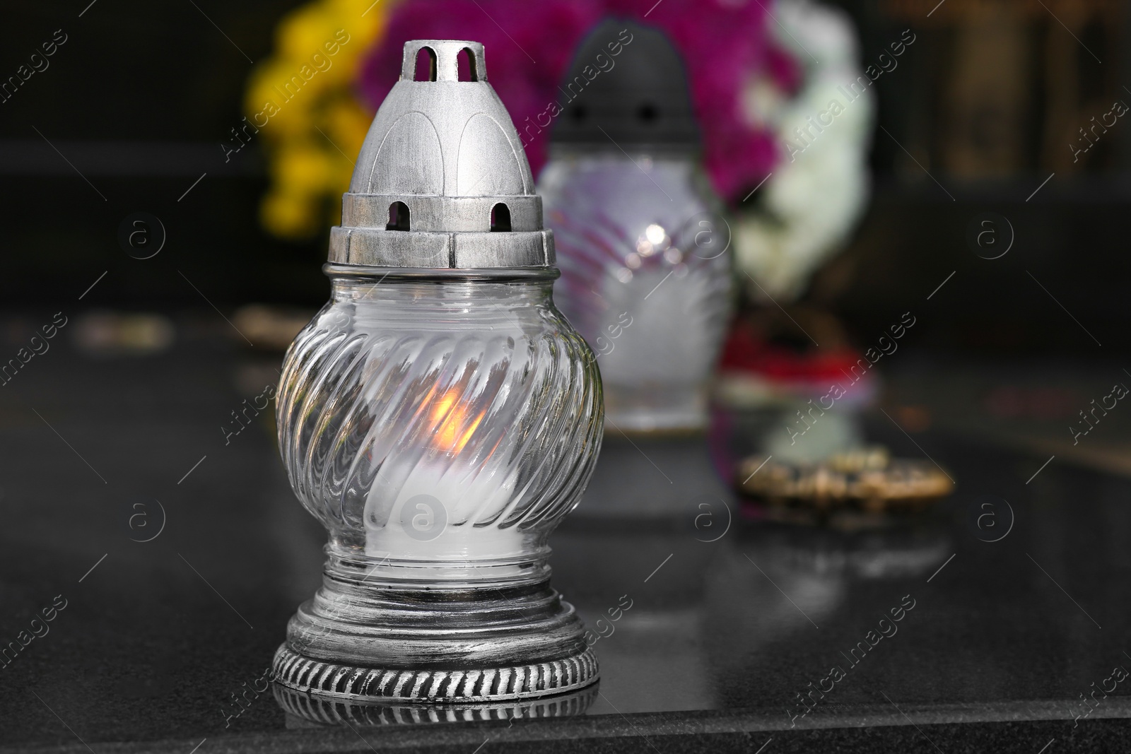 Photo of Grave lanterns on granite surface in cemetery, space for text