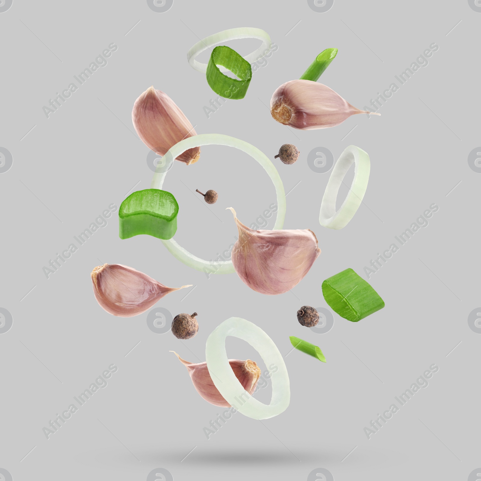 Image of Different spices falling on light grey background