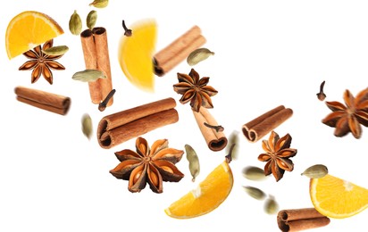 Pieces of fresh orange, aromatic anise stars, cinnamon, cloves and cardamom falling on white background