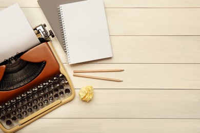Photo of Vintage typewriter, stationery and crumpled paper on white wooden table, flat lay. Space for text