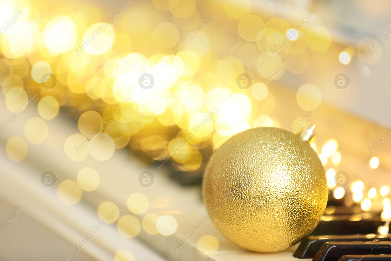 Image of Christmas and New Year music. Piano with festive ball, bokeh effect