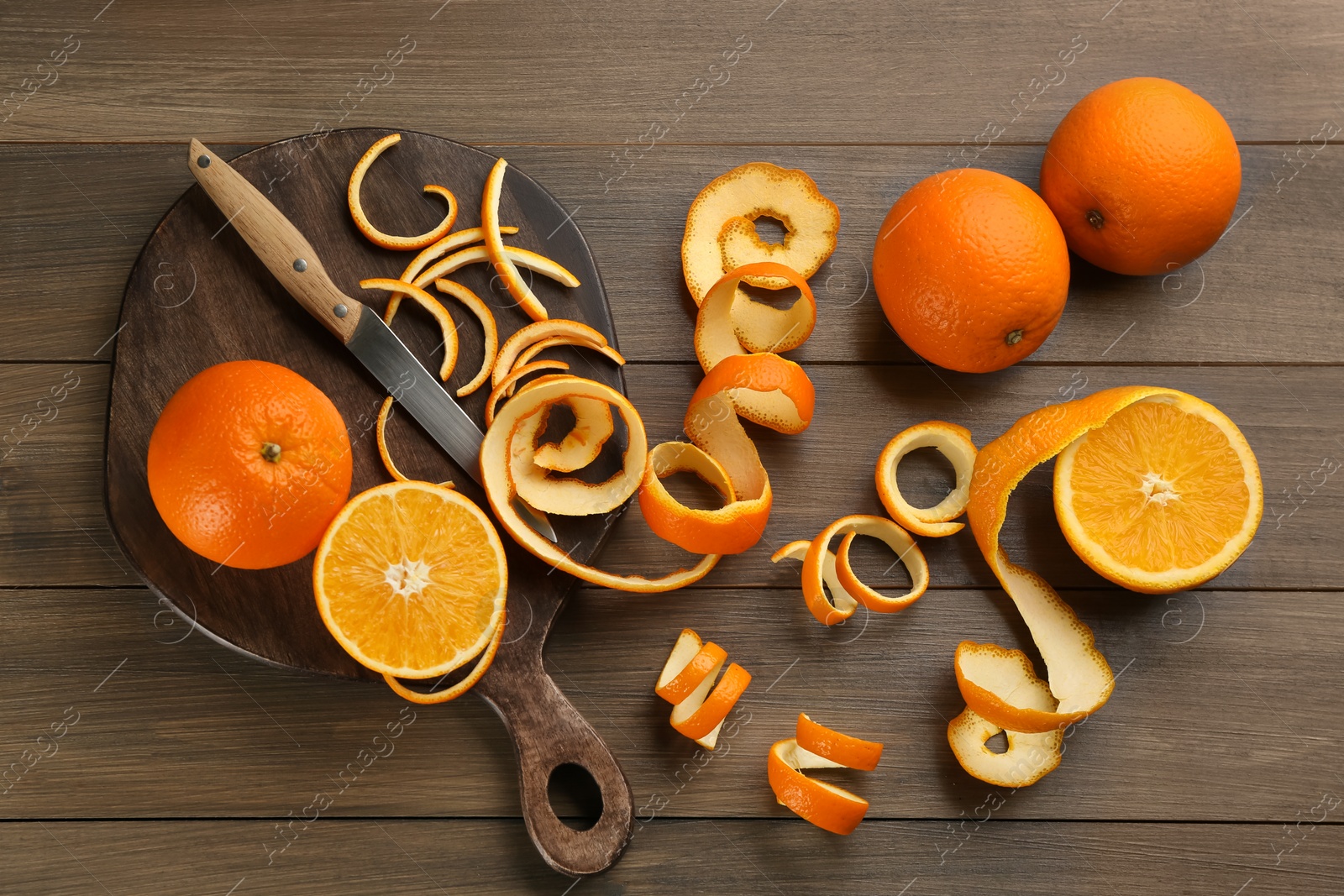 Photo of Orange fruits with peels on wooden table, flat lay