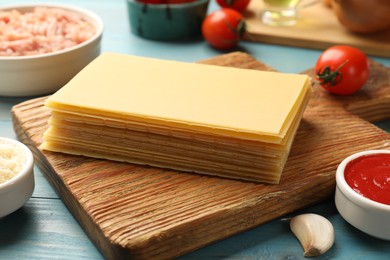Ingredients for lasagna on blue wooden table, closeup