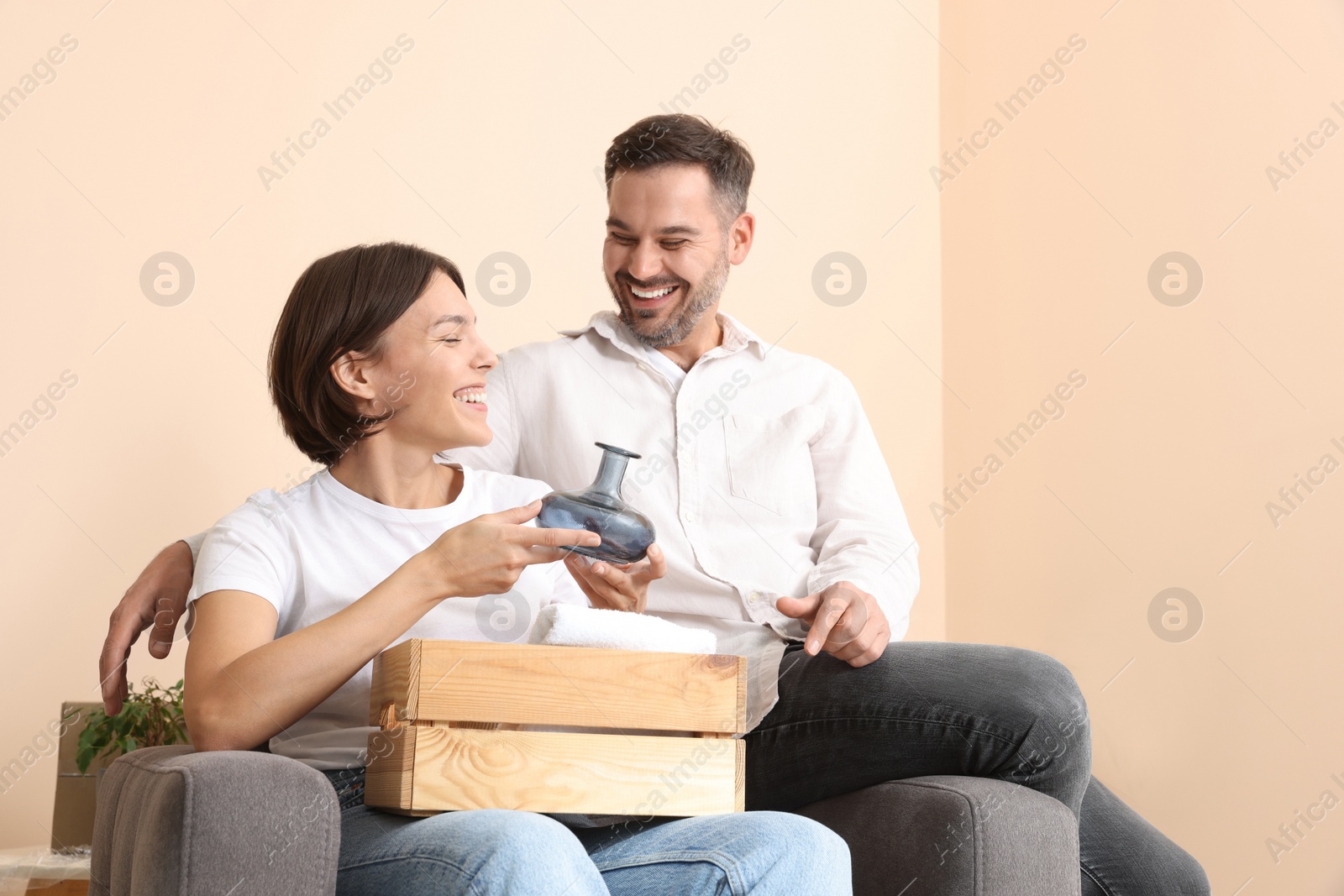 Photo of Happy couple unpacking box in new apartment. Moving day