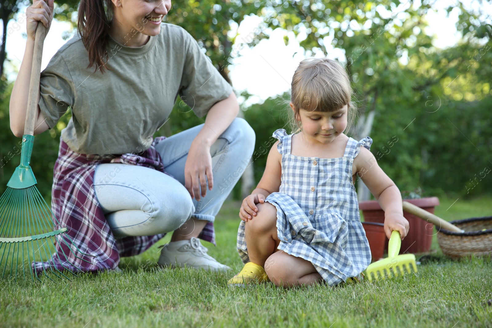 Photo of Mother and her daughter working together in garden