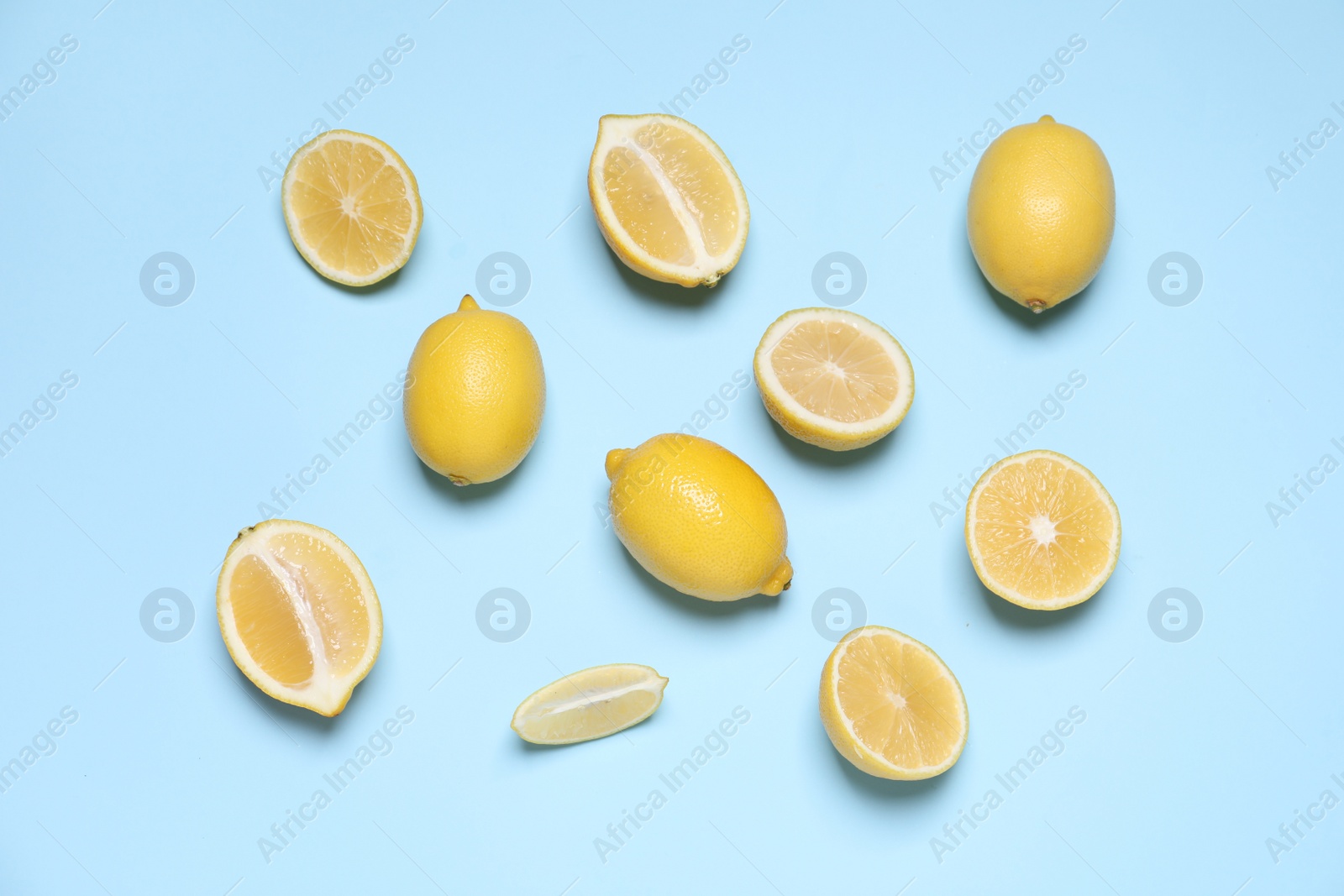 Photo of Many fresh ripe lemons on light blue background, flat lay