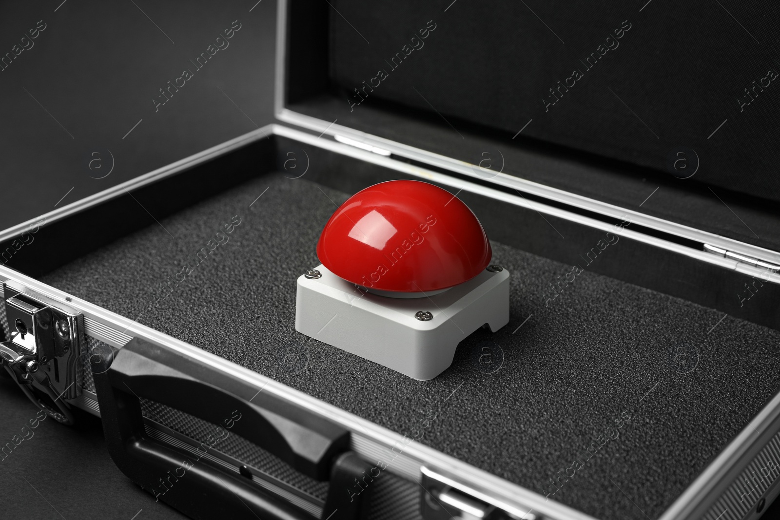 Photo of Red button of nuclear weapon in suitcase on black background. War concept