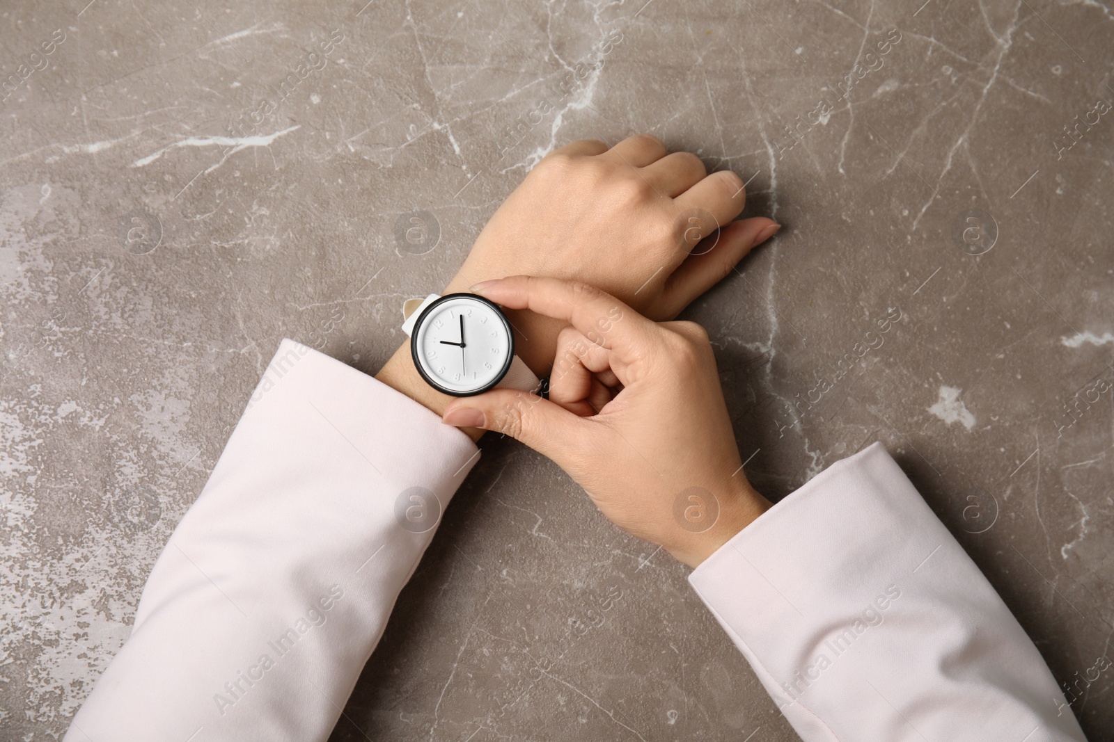 Photo of Businesswoman with stylish wrist watch at table, top view. Time management