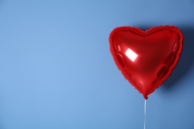 Photo of Red heart shaped balloon on blue background, space for text. Valentine's Day celebration