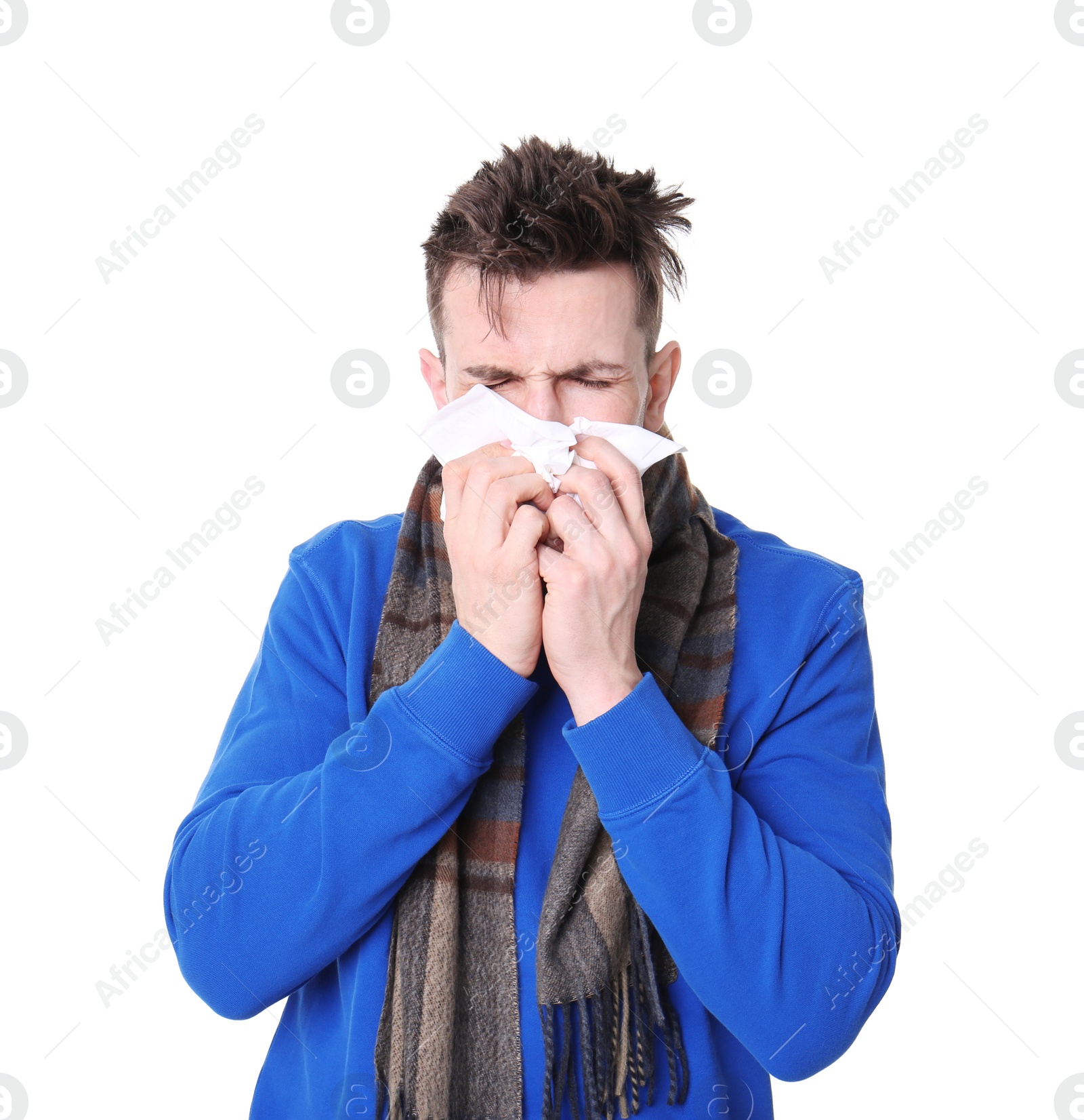 Photo of Young man with cold sneezing on white background