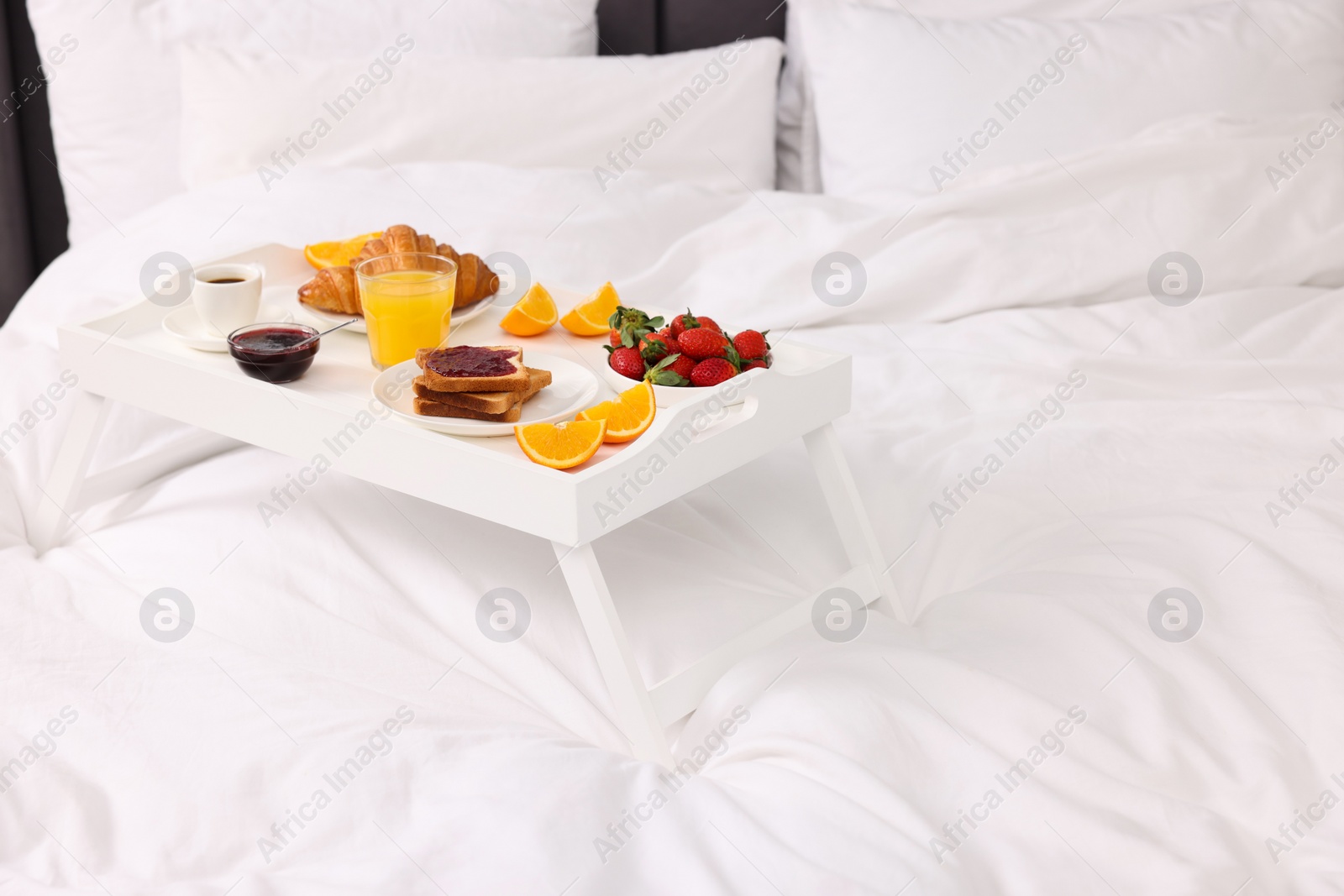 Tray with delicious breakfast on bed, closeup. Space for text Photo of Tray with delicious breakfast on bed, closeup. Space for text