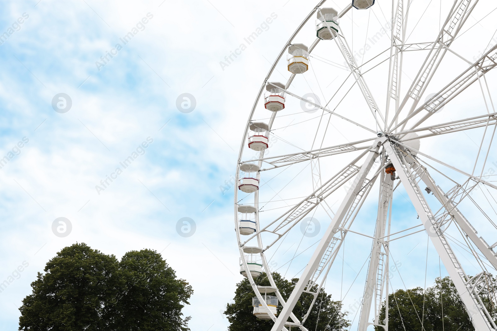 Photo of Large white observation wheel against sky, space for text