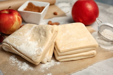 Raw flaky dough and ingredients on table