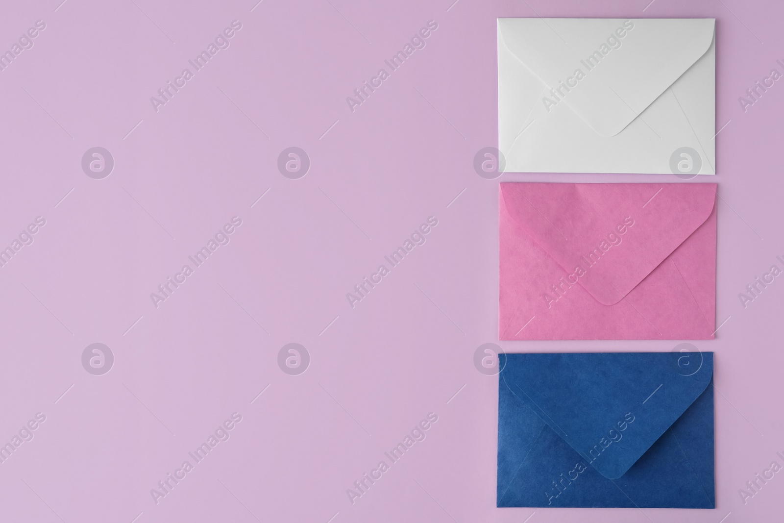 Photo of Colorful paper envelopes on pink background, flat lay. Space for text