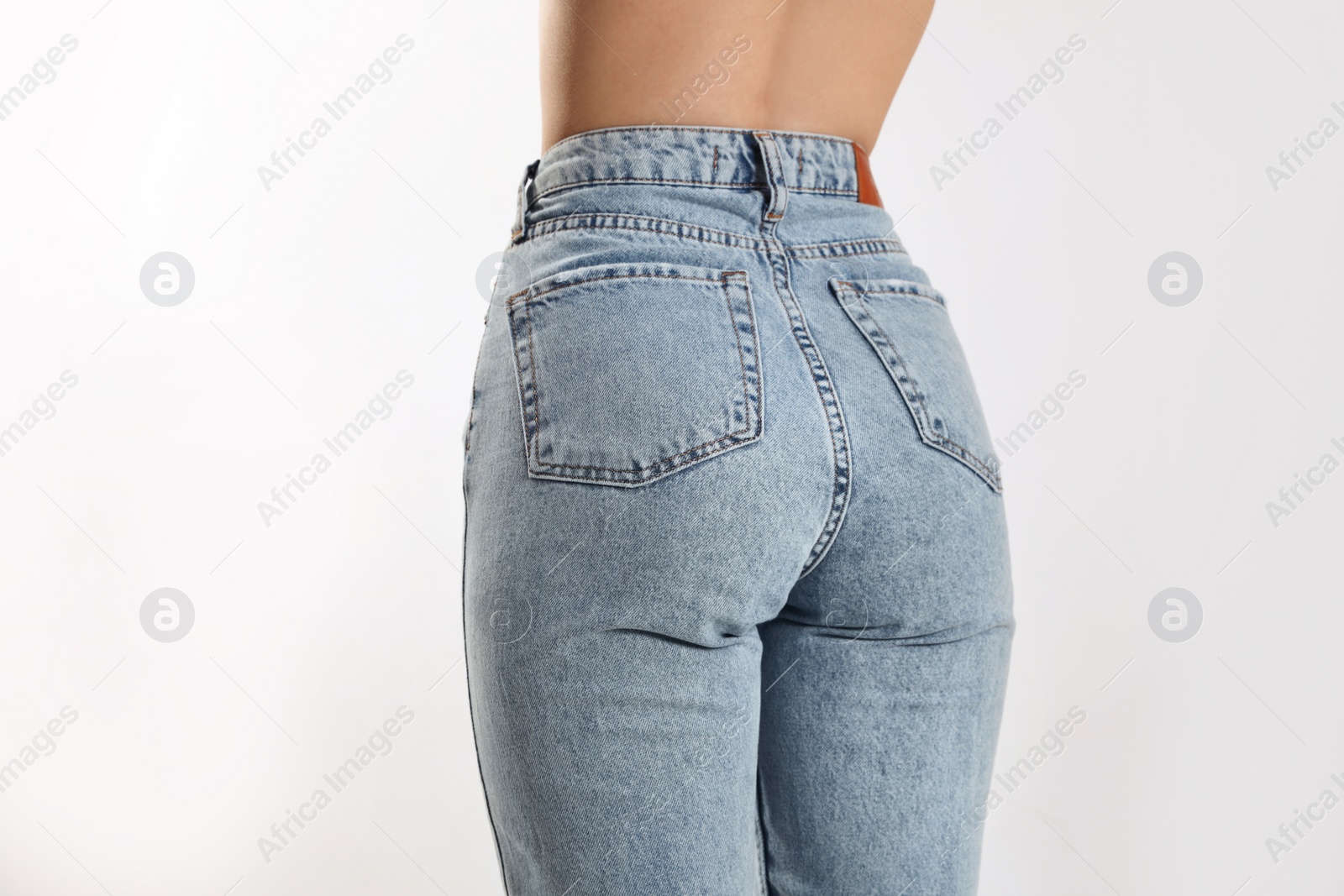 Photo of Woman in stylish jeans on light background, closeup