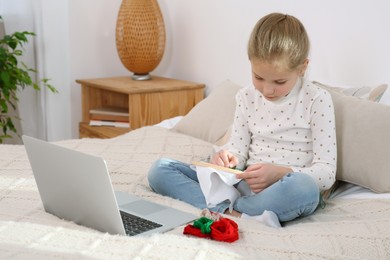 Photo of Little girl learning to embroider with online course at home. Space for text