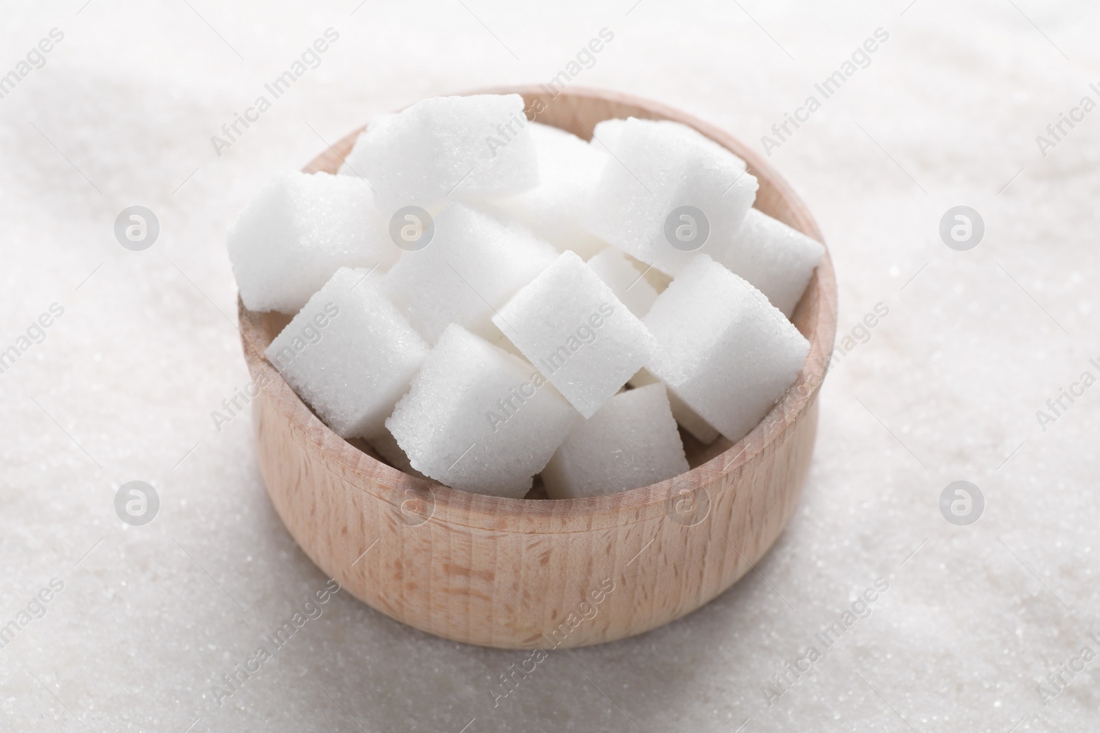 Photo of Different types of white sugar and bowl as background, closeup